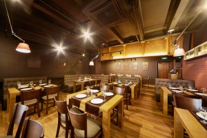 Interior of room in restaurant with wooden furniture and walls o
