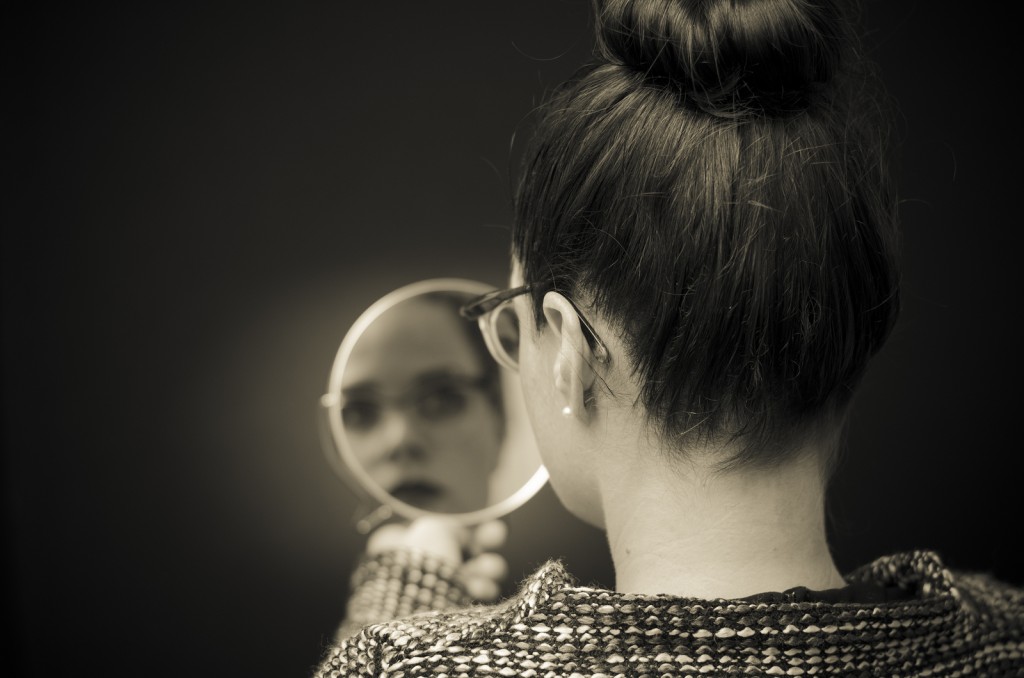 Woman Looking At Self Reflection In Mirror..