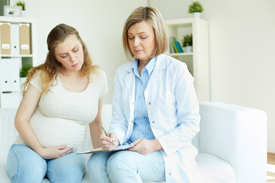 Young pregnant woman listening to prescription of doctor after r