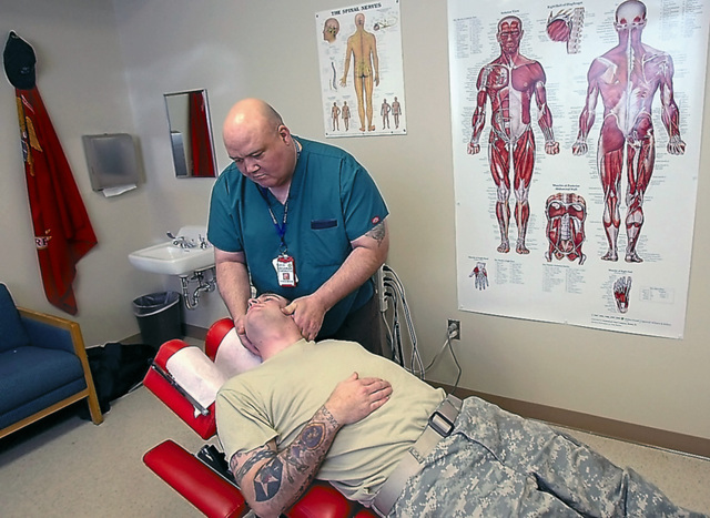 An Army report recommended the use of alternatives to pain drugs, including chiropractic care, massage and acupuncture. Here, Dr. Frank Lawler gives Spc. David Ash chiropractic treatment, January 7, 2011, in Tacoma, Washington. (Mark Harrison/Seattle Times/MCT)