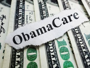Closeup of an Obamacare newspaper headline on cash